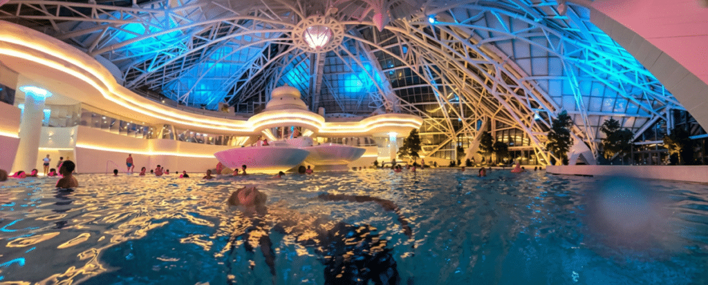 Foto de la nueva laguna interior de Caldea de noche iluminada bajo la cúpula de cristal