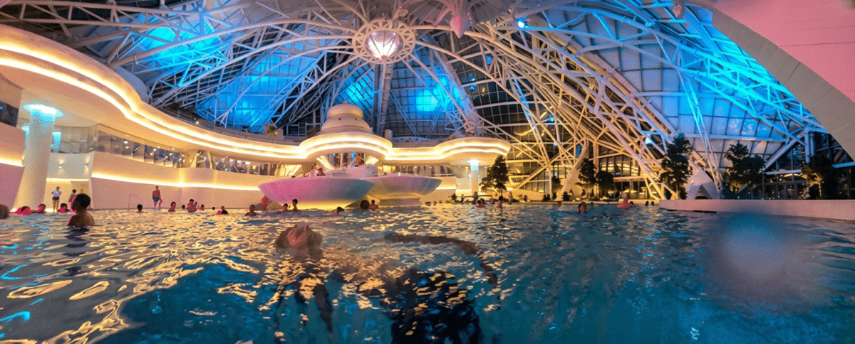 Foto de la nueva laguna interior de Caldea de noche iluminada bajo la cúpula de cristal