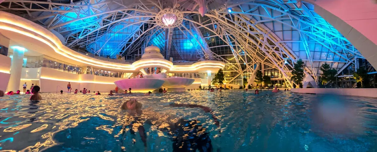 Foto de la nueva laguna interior de Caldea de noche iluminada bajo la cúpula de cristal